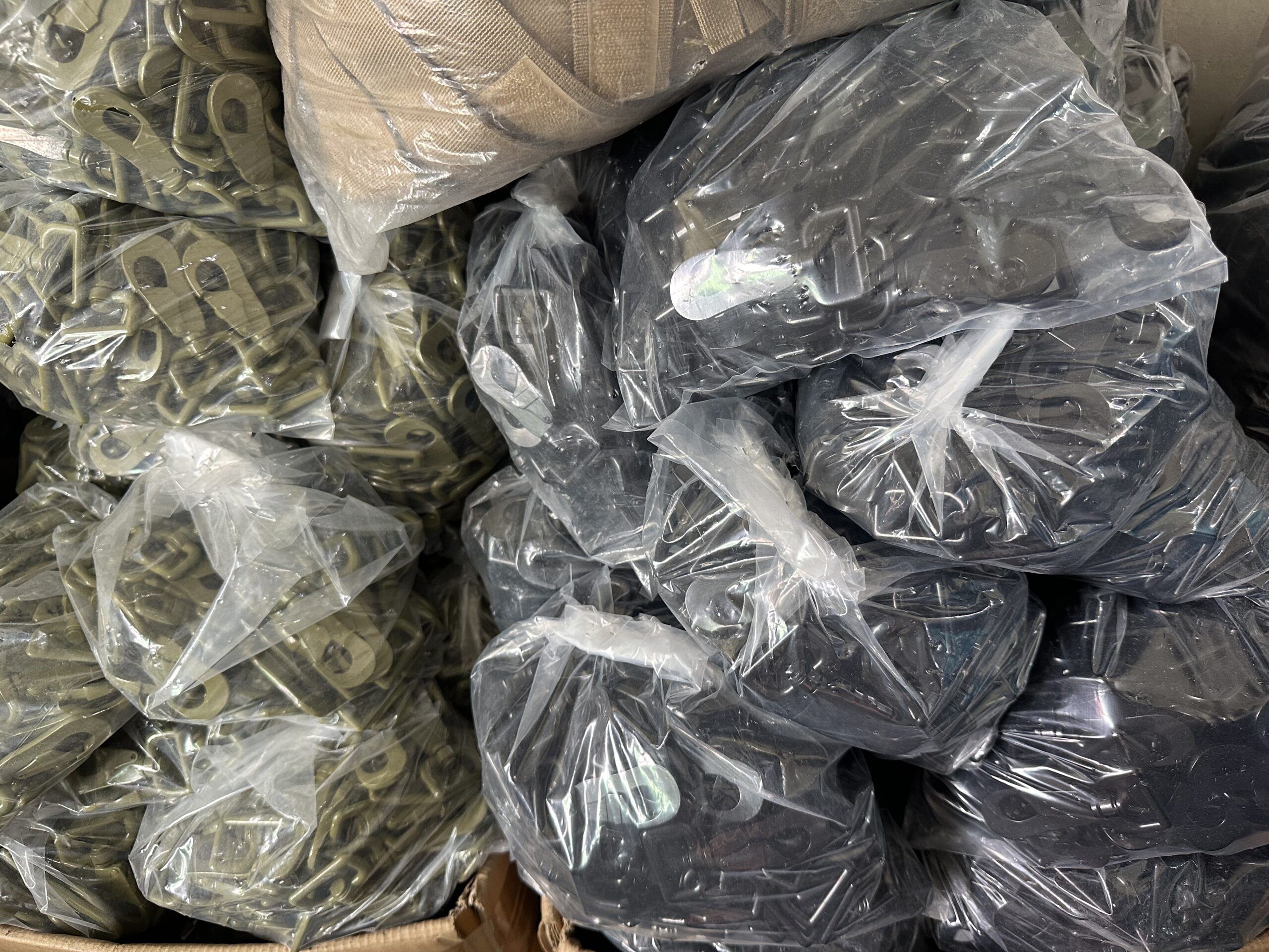 Olive and black plastic hardware parts packed in clear bags