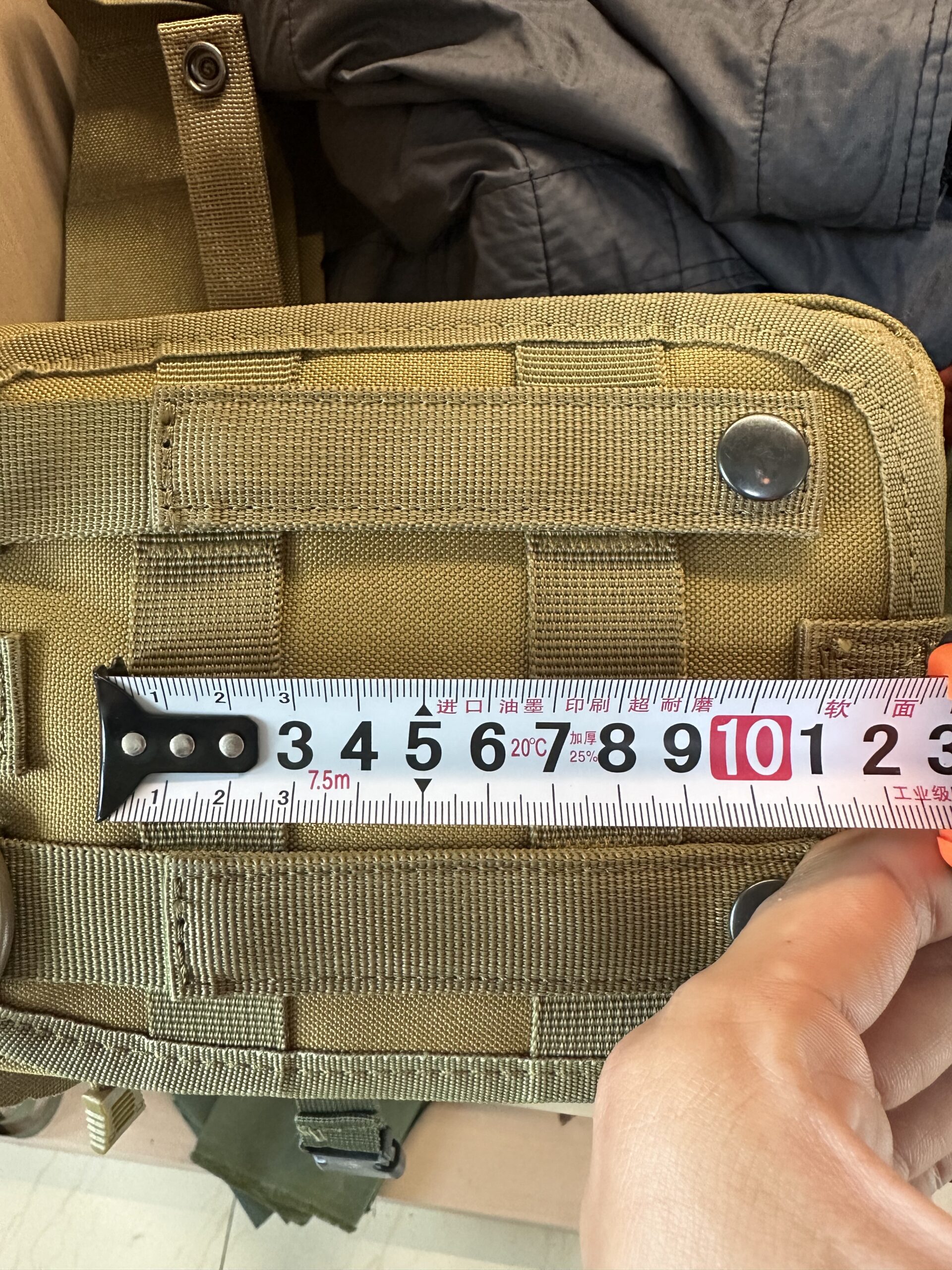 Tape measure checking the width of a coyote MOLLE pouch
