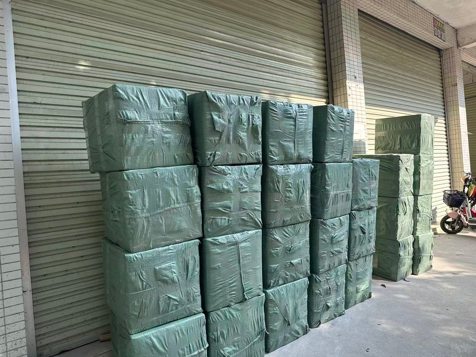 Packed tactical gear bales stacked outside PANOAR factory loading dock ready for shipment