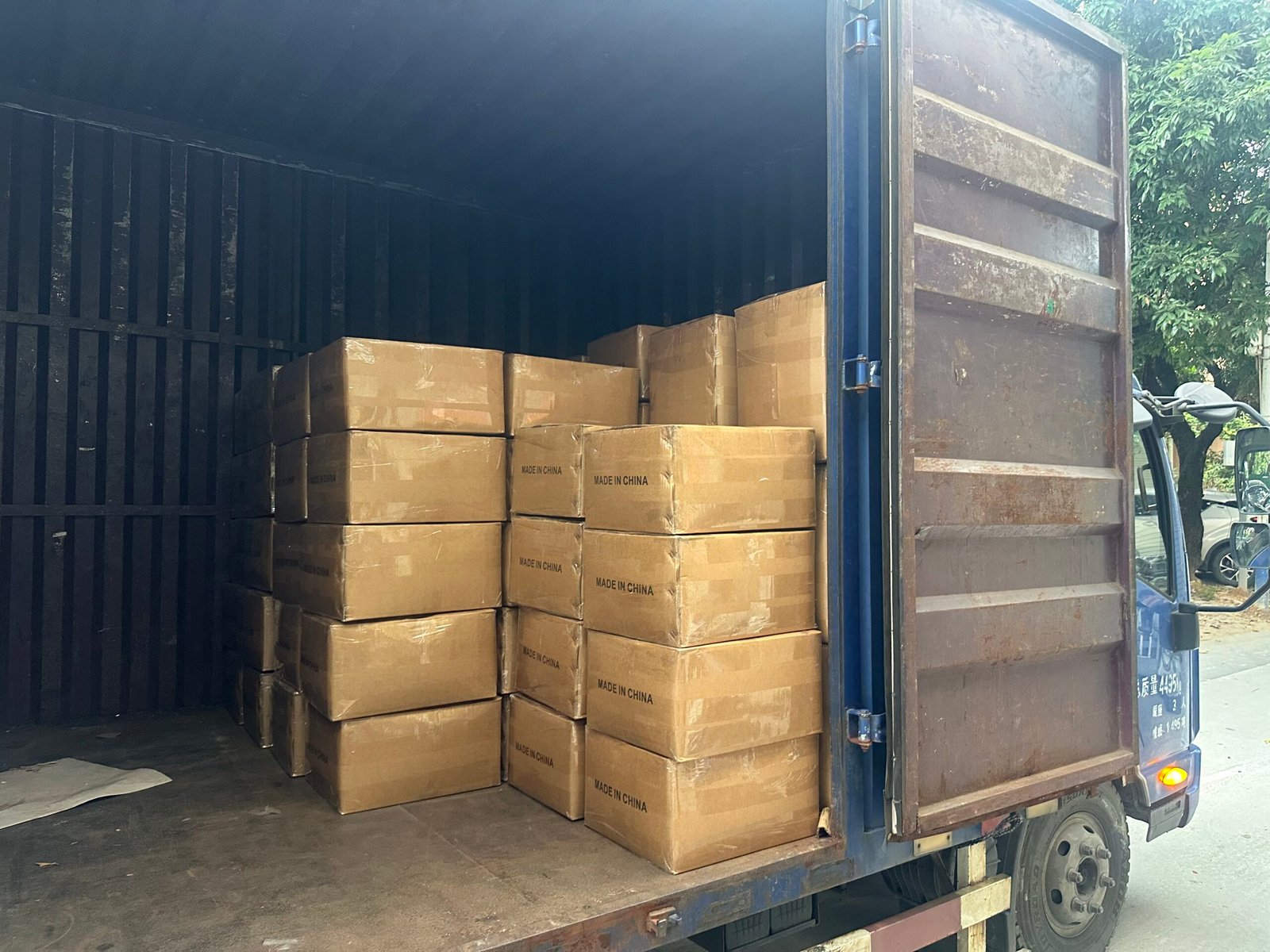 Tactical gear cartons marked Made in China loaded onto truck for export shipment