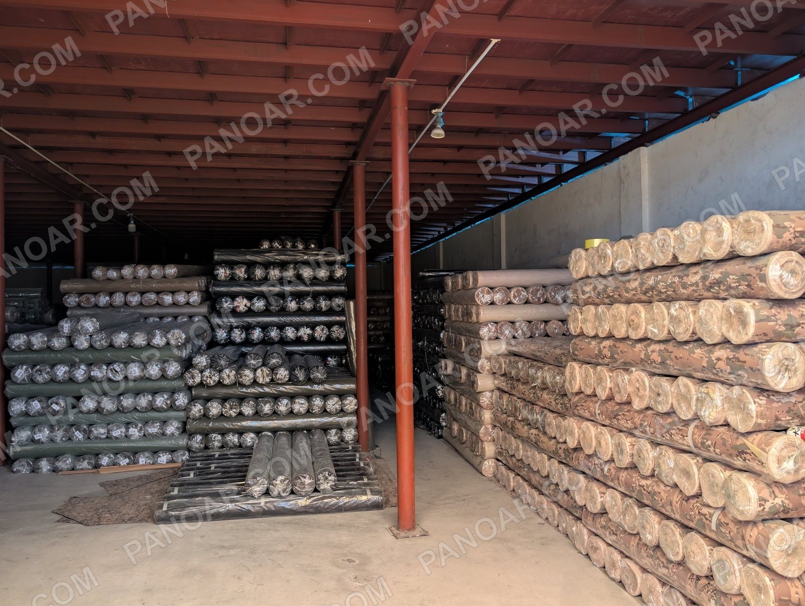 Camouflage and solid fabric rolls on shelves