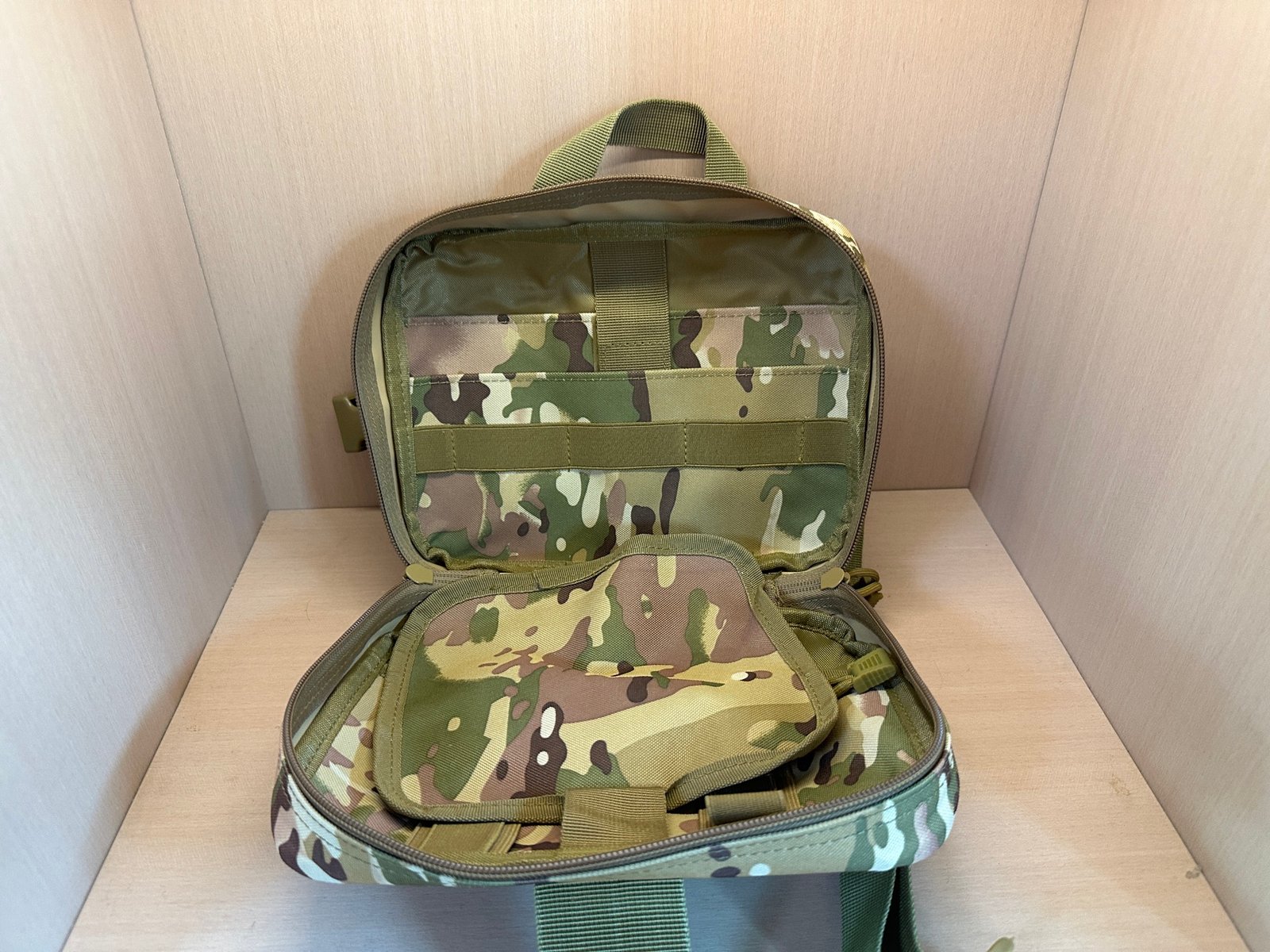 Open camouflage medical pouch reference showing internal organizer panel and elastic retention layout