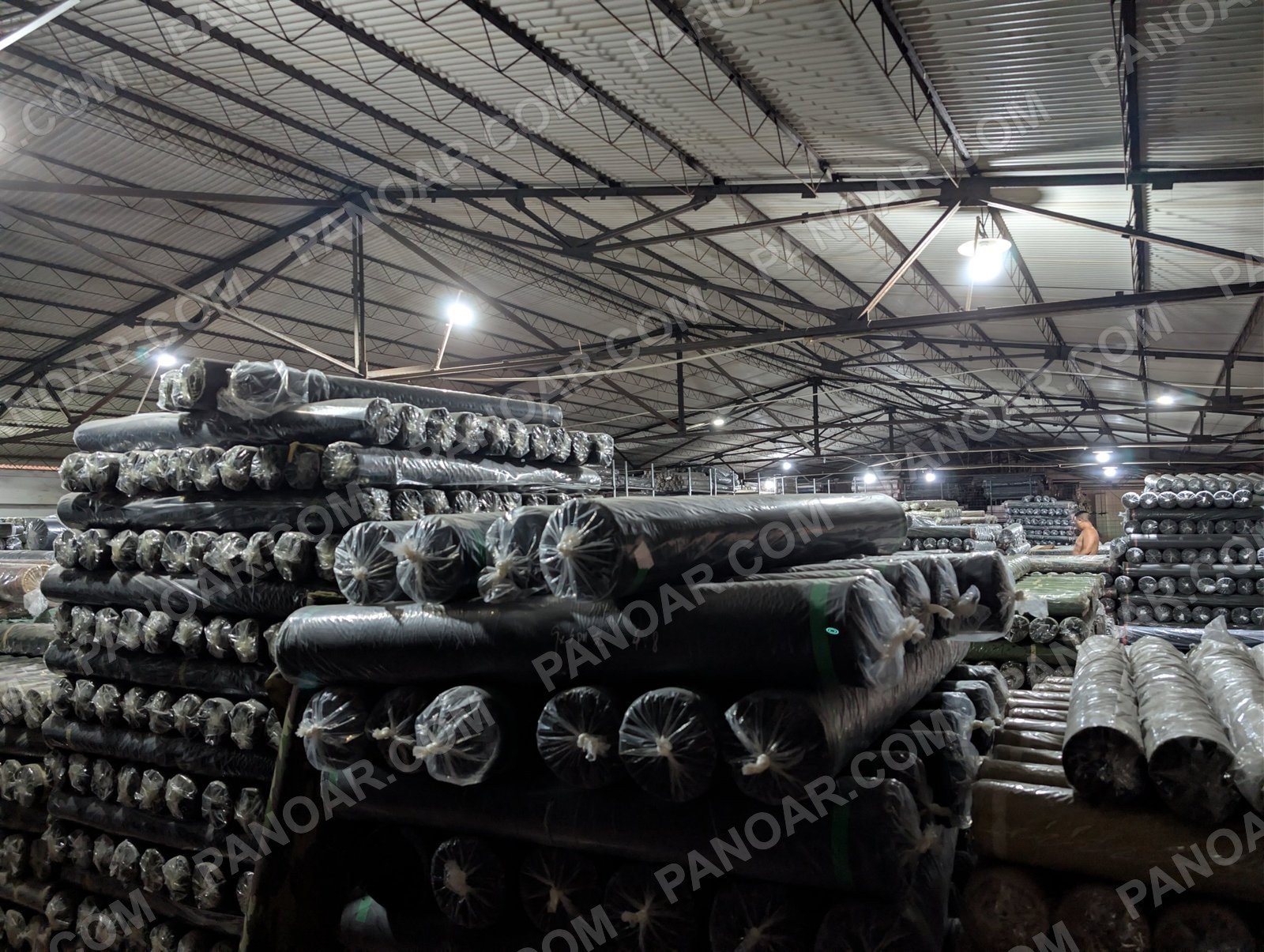 Stacks of wrapped dark fabric rolls