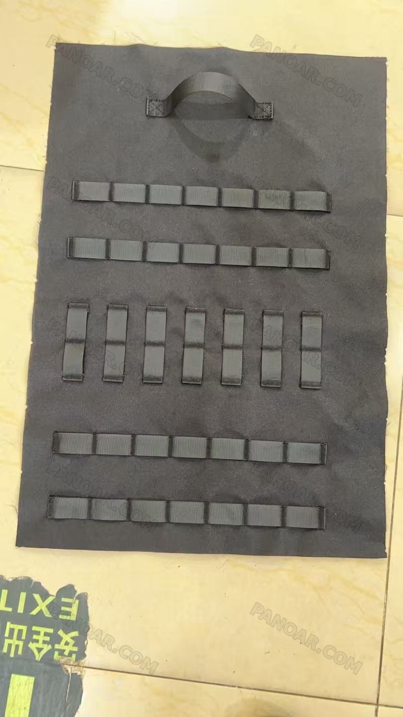 Black panel laid flat with rows of sewn webbing loops and a top grab handle