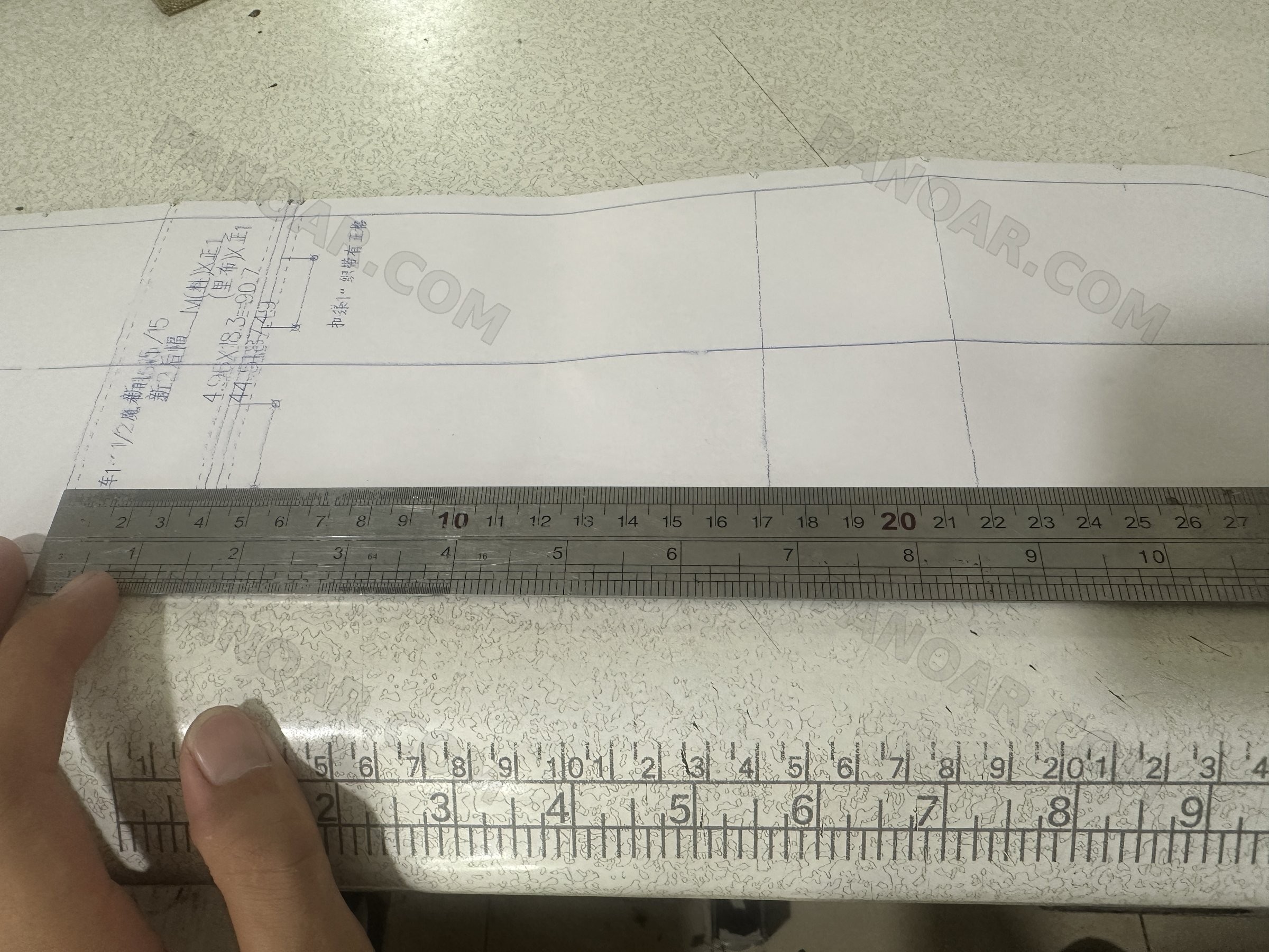 Paper pattern with handwritten notes and steel rulers