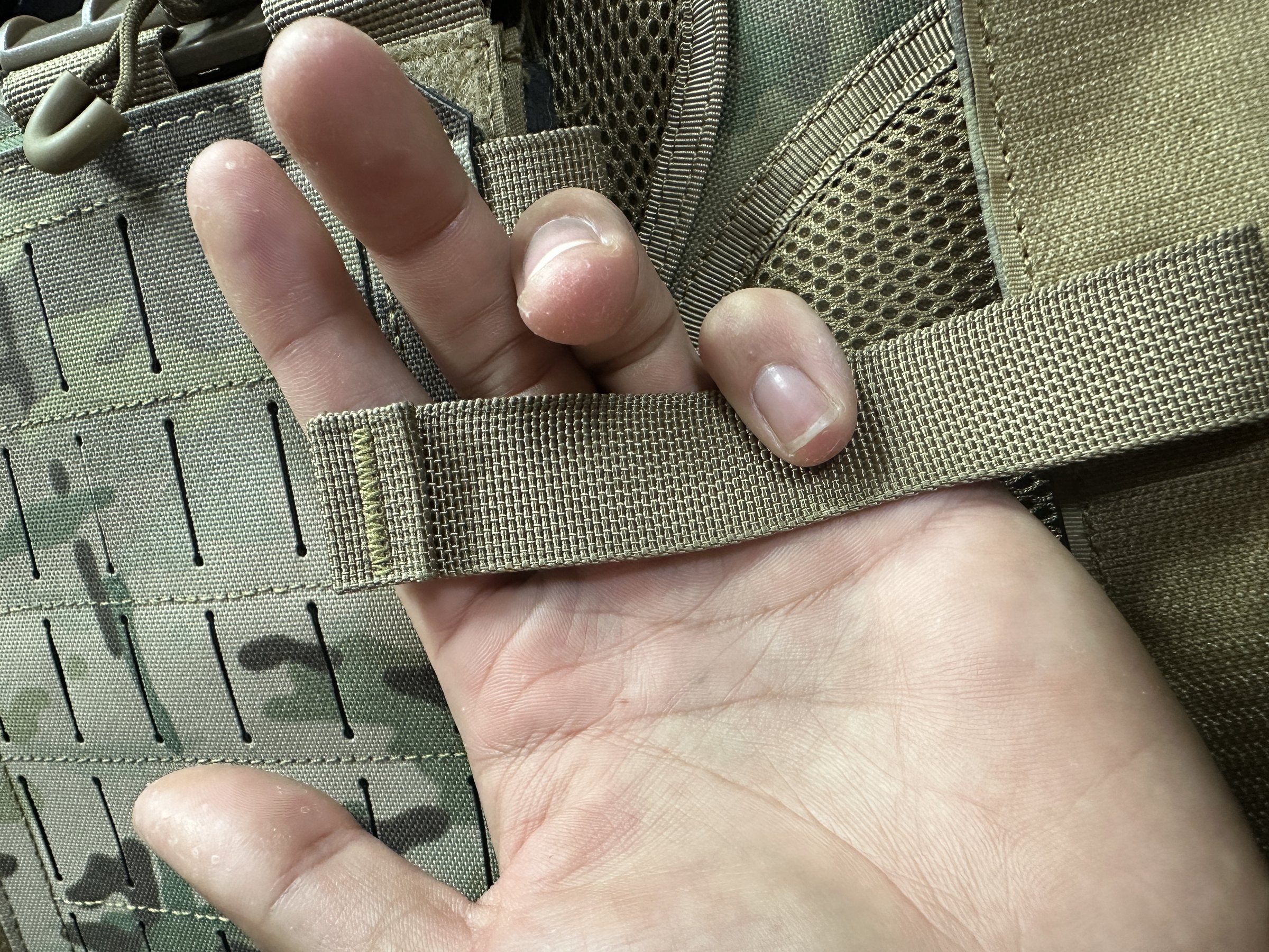 MOLLE webbing tab detail on a black plate carrier