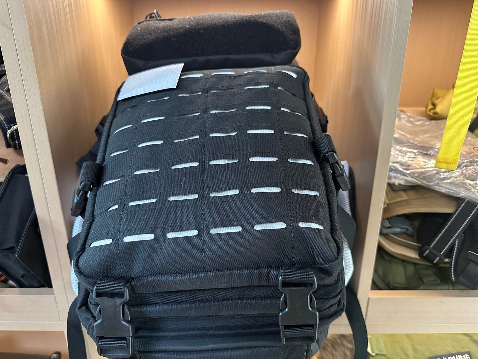 Black tactical backpack reference with laser-cut MOLLE panel and front buckle details
