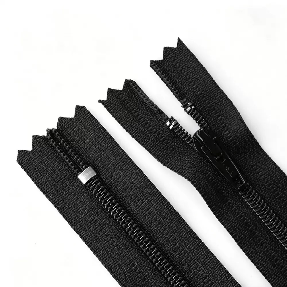 Two black zipper samples showing tape, teeth, a metal stop and a slider on a white background.