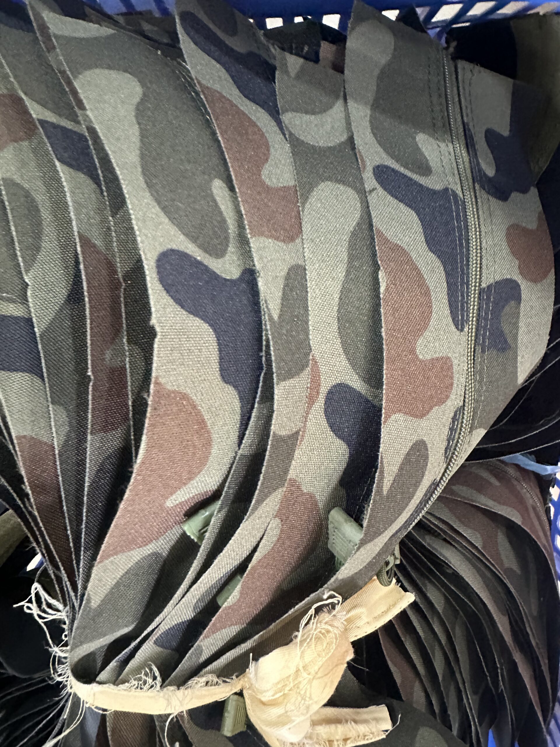 Camouflage fabric panels with a zipper visible on one panel.