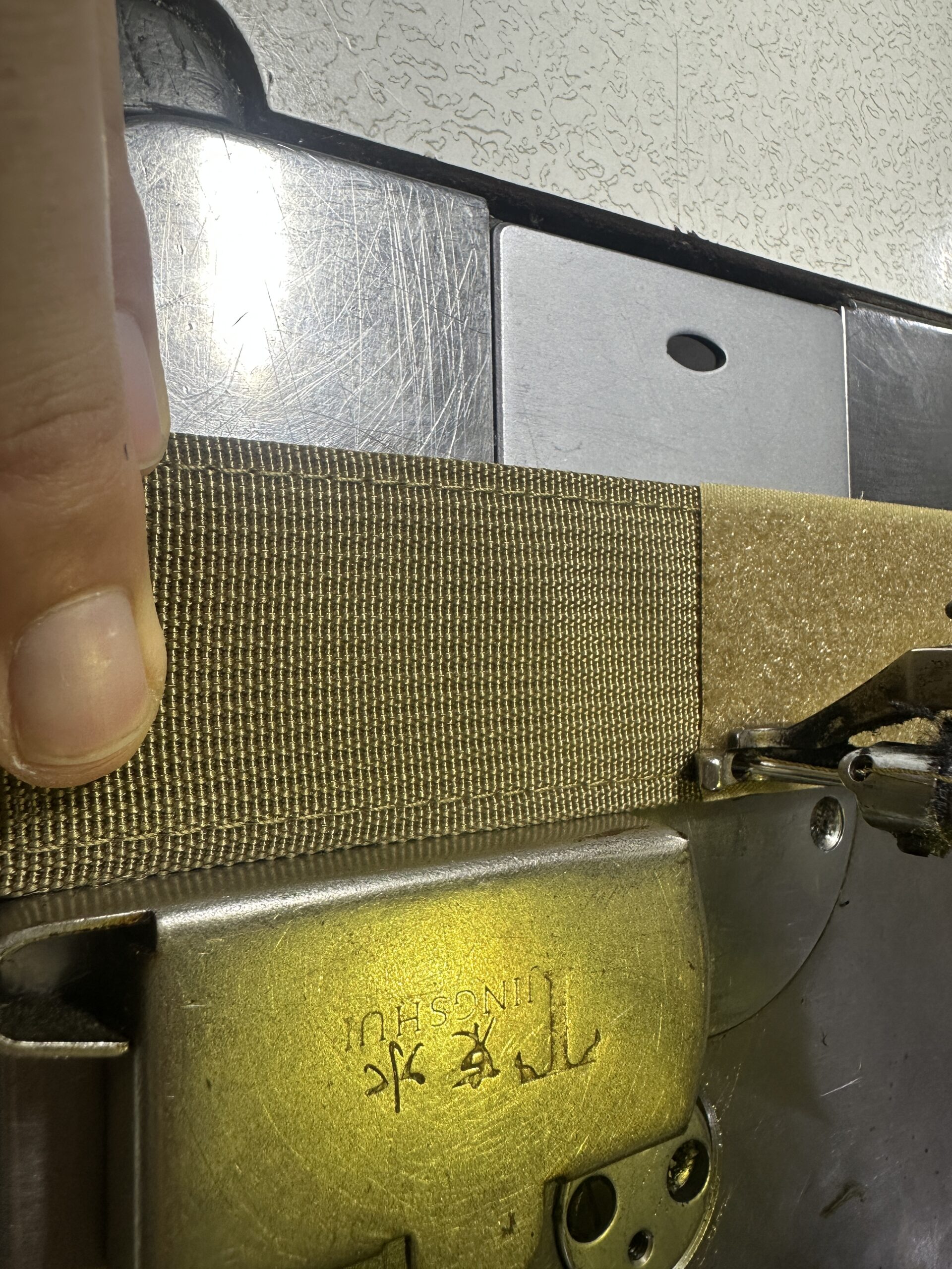Khaki webbing positioned at a sewing machine in the PANOAR factory