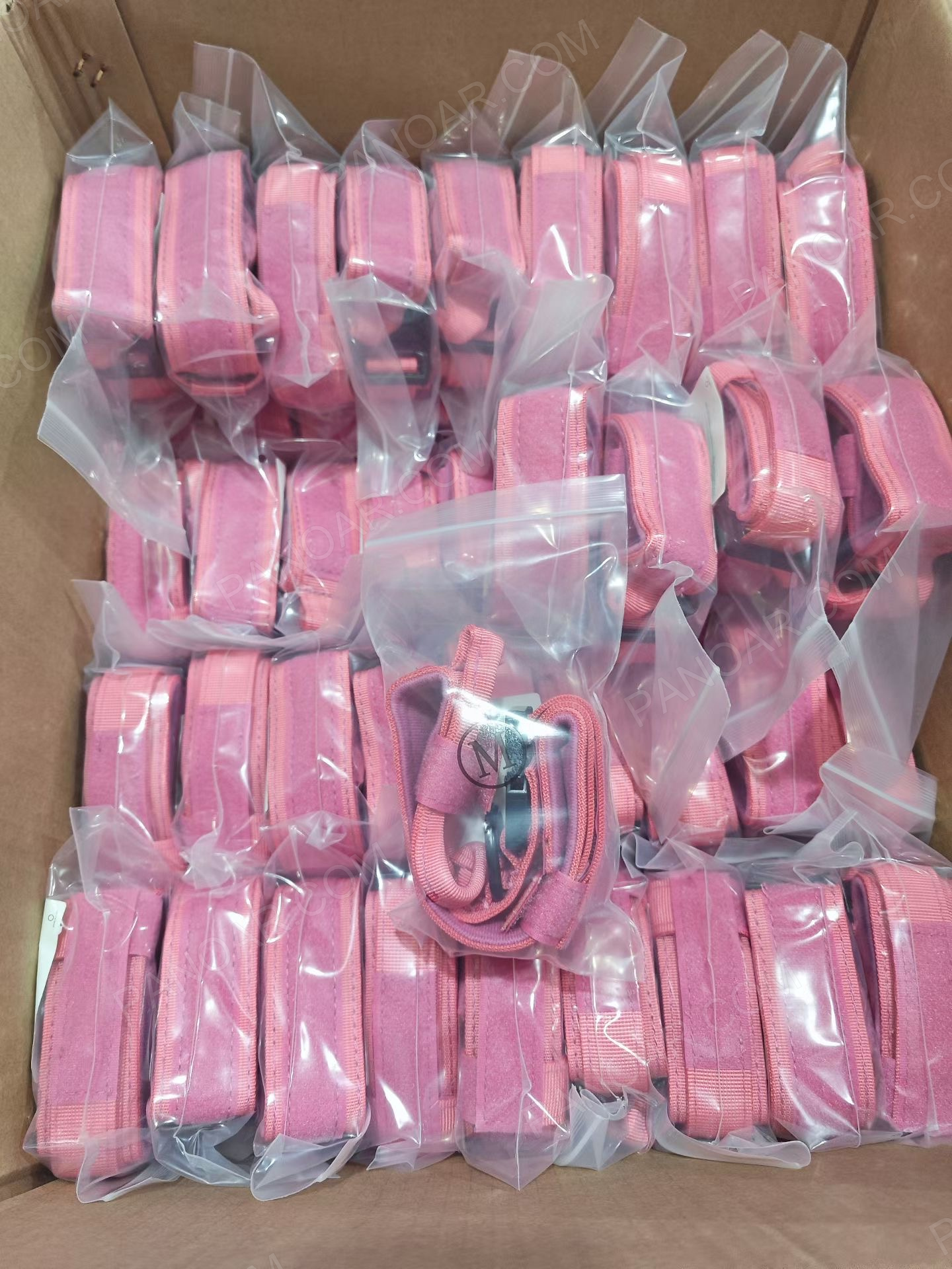 Pink dog collars in individual clear bags arranged in a carton